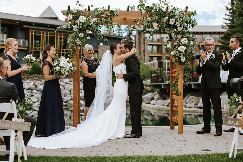 Couple kissing at their outdoor wedding ceremony at the Azuridge Estate Hotel, sophisticated and romantic Foothills, Alberta wedding venue, featured on the Brontë Bride Vendor Guide.