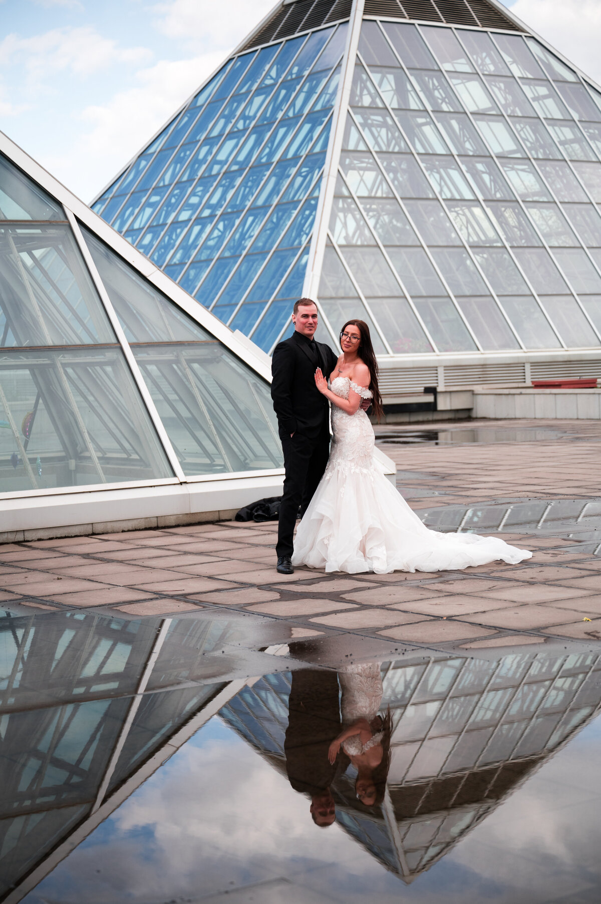Bride and groom wedding portrait, reflection in puddle