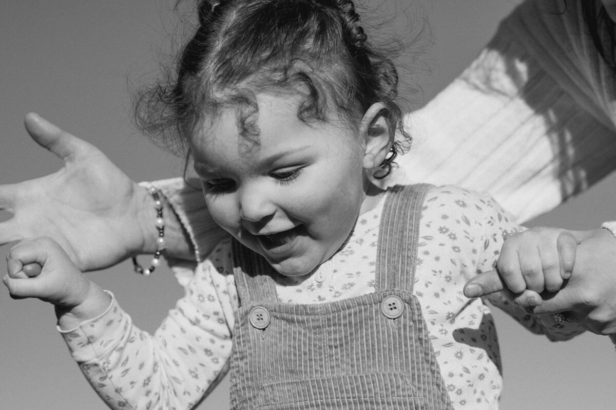 toddler smiling and having fun with her mom during outdoor photoshoot in Bend, Oregon