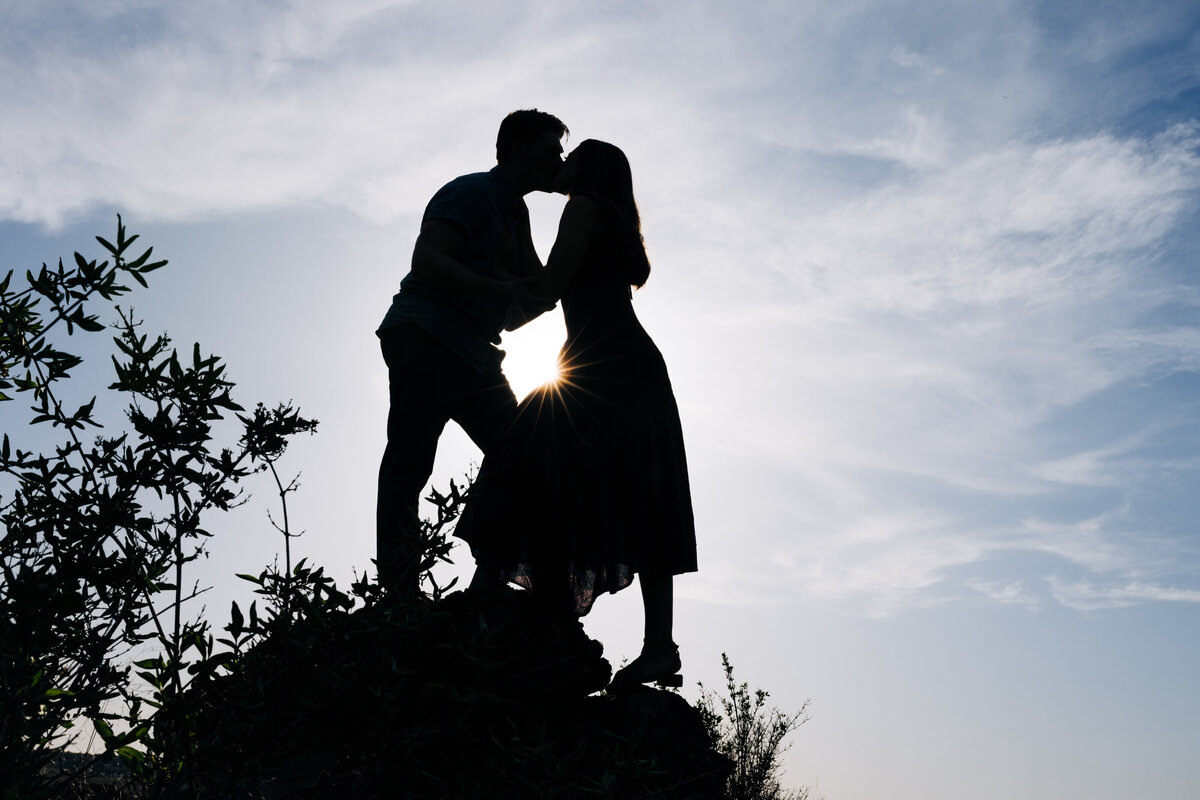 Silhouette engagement photo couple kissing