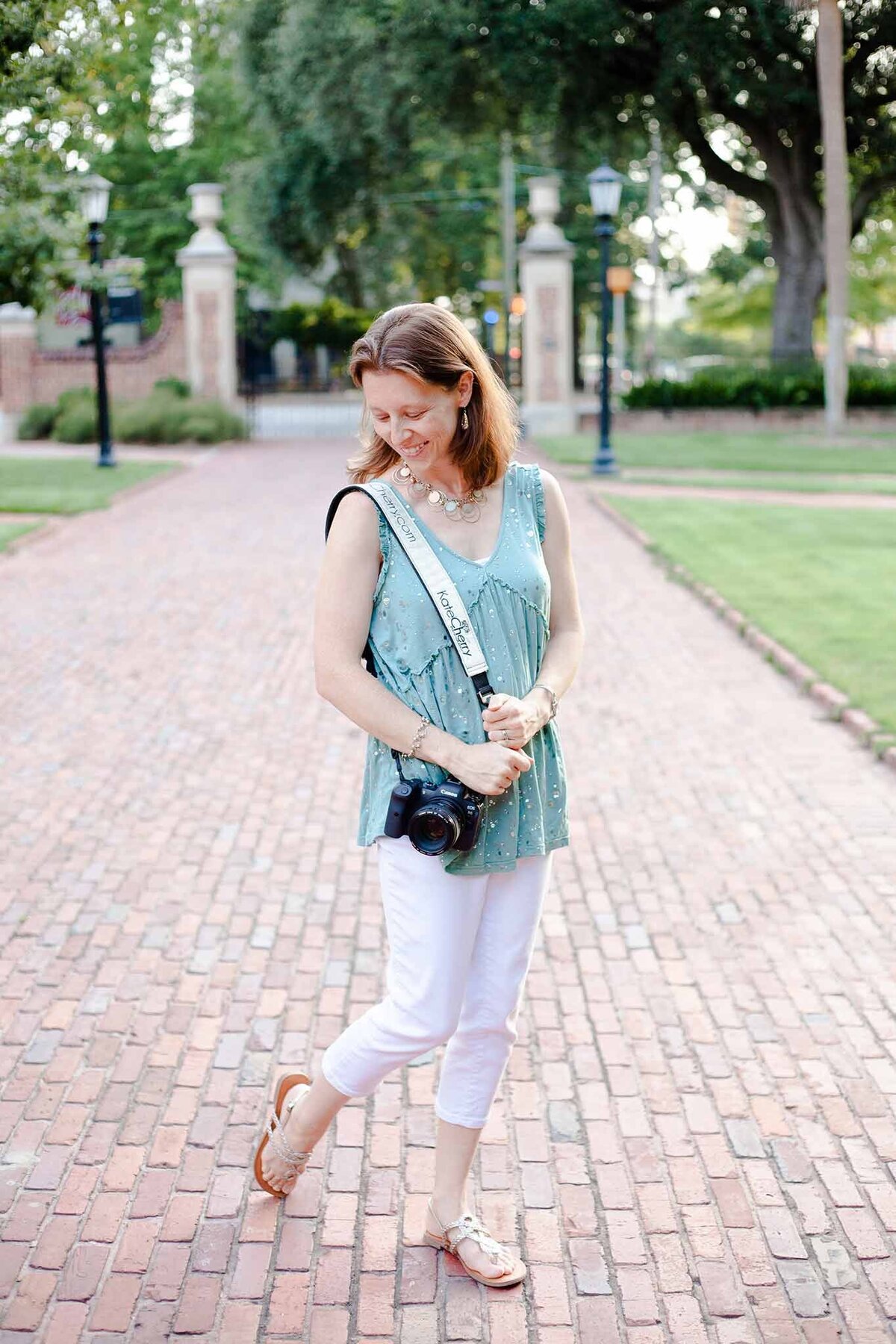 Kate Cherry with Kate Cherry Photography, LLC at USC Horseshoe in Columbia, SC looking down her shoulder while holding her camera