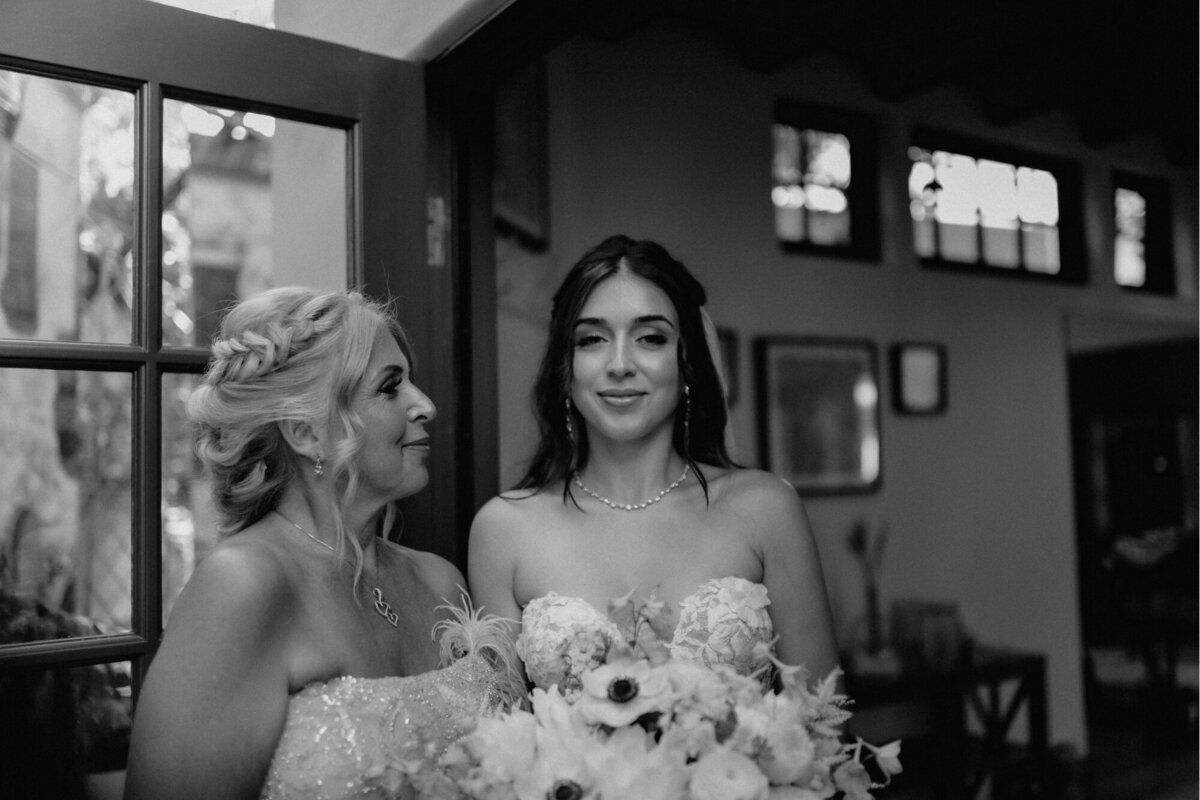 Bride smiling with one of the women from the bridal party before walking down the isle.