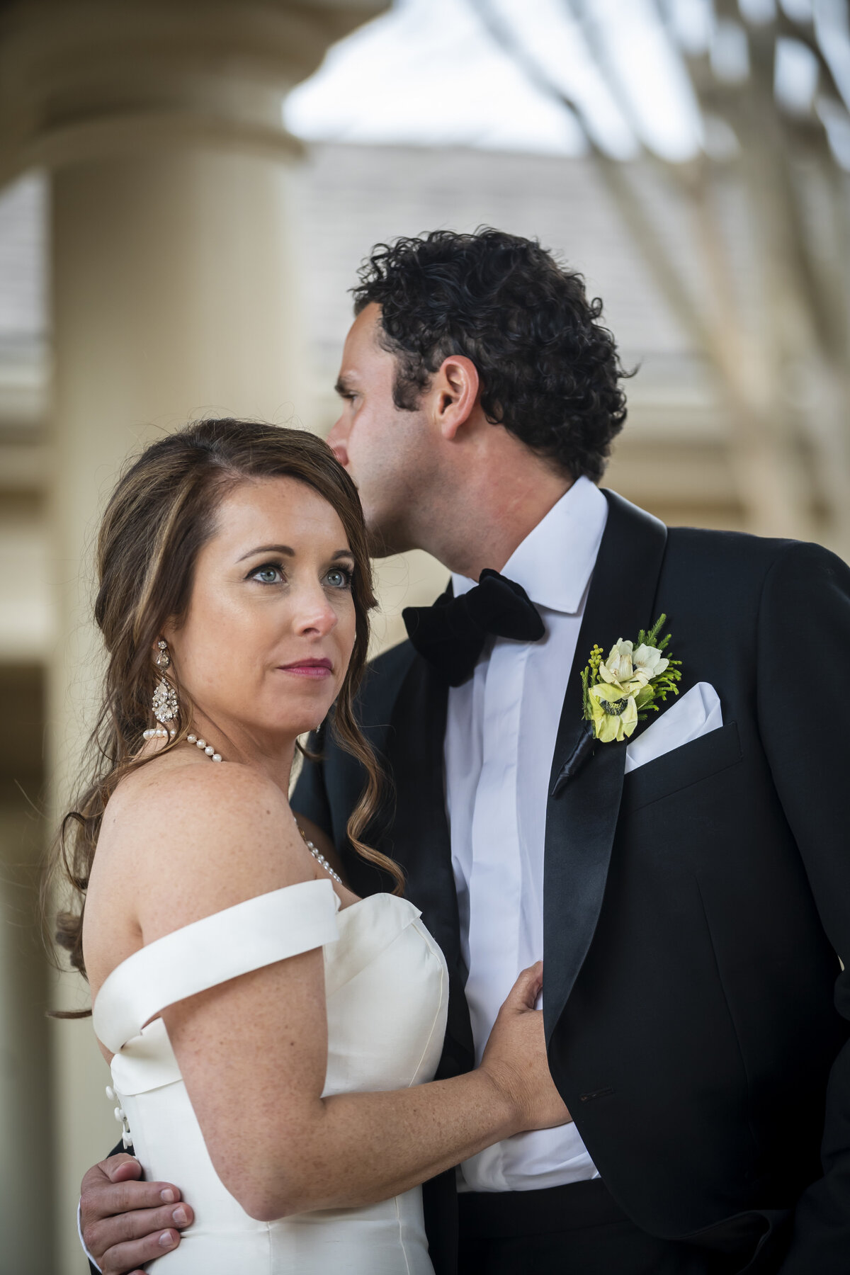 Bride staring forward while groom is looking behind her.