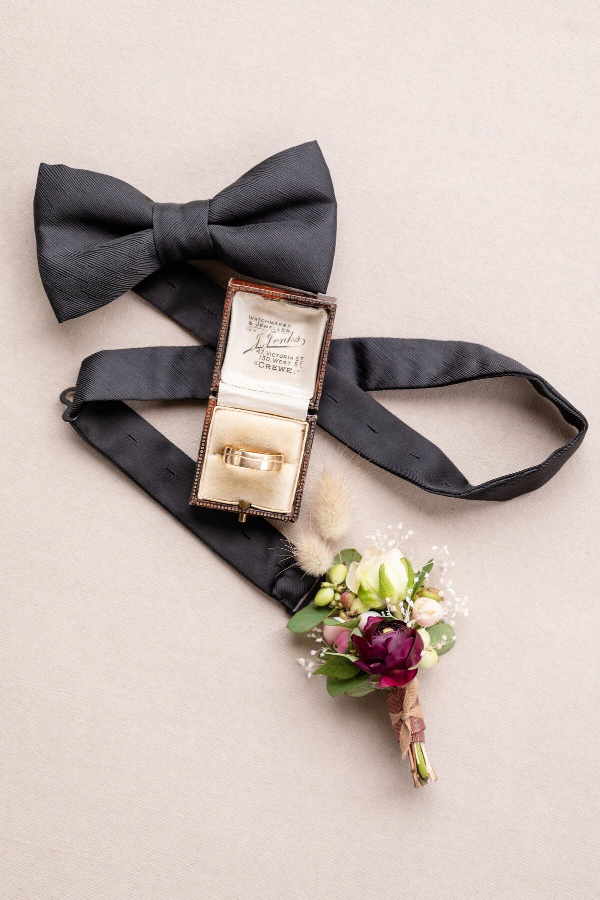 Groom-details-bowtie-rings-and-bouteniere-at-graydon-hall-manor
