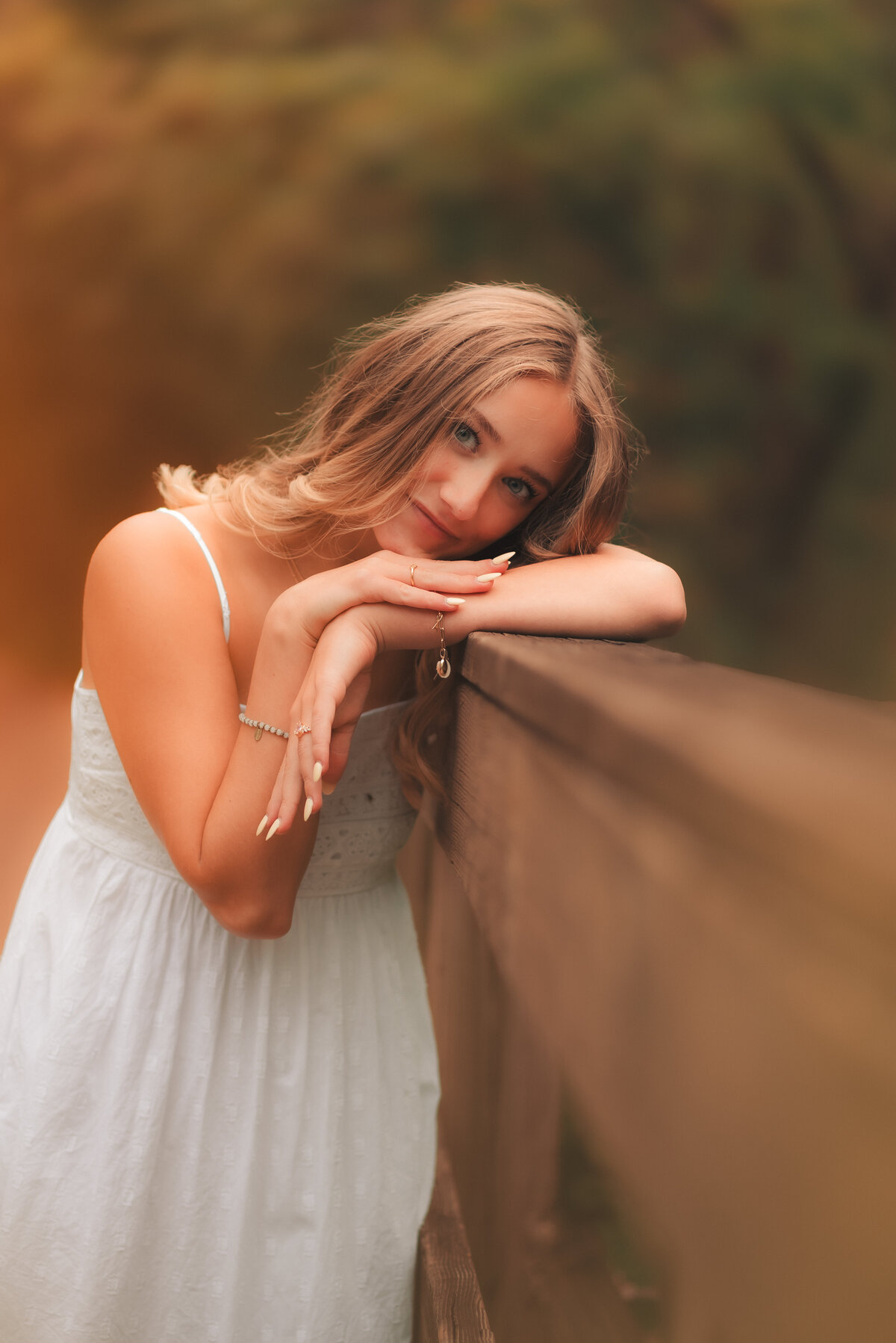 Senior portrait of graduate posing in tall grass field with soft golden light, taken near Minneapolis and St. Paul.
