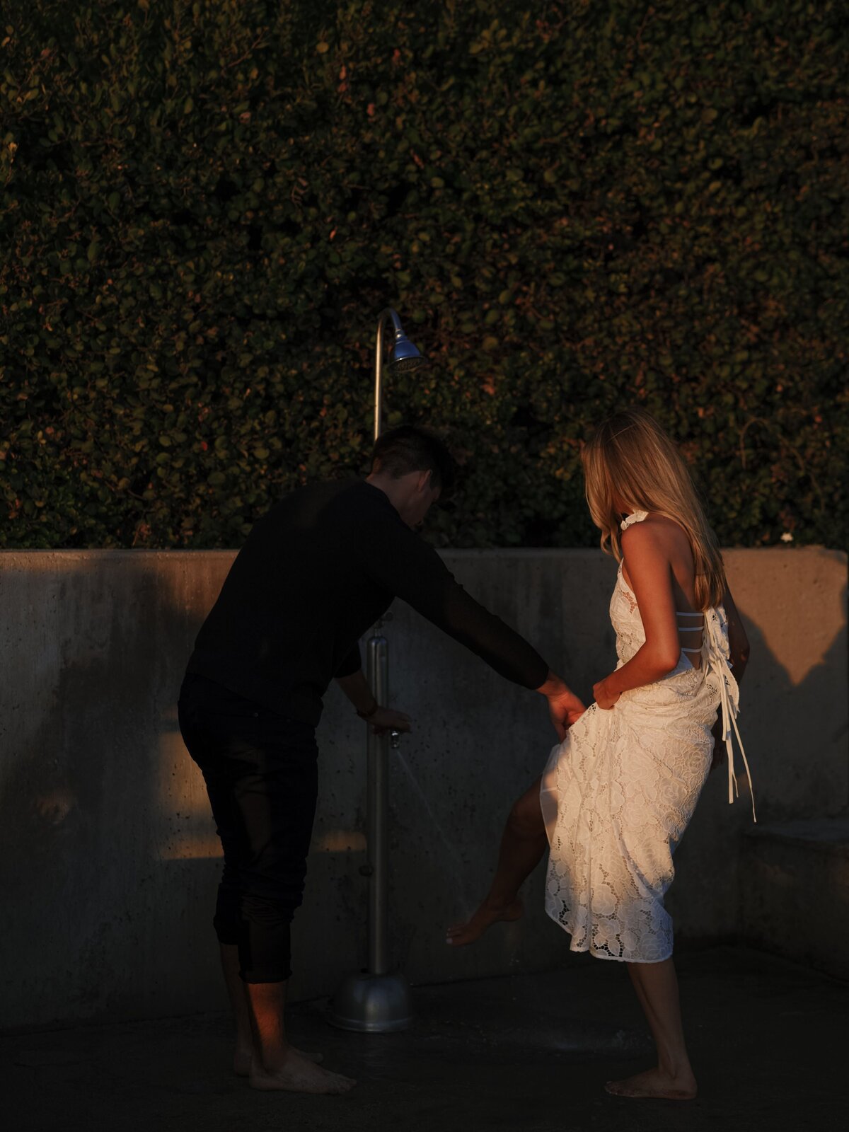 Laguna Beach couple washing off feet after sunset beach session