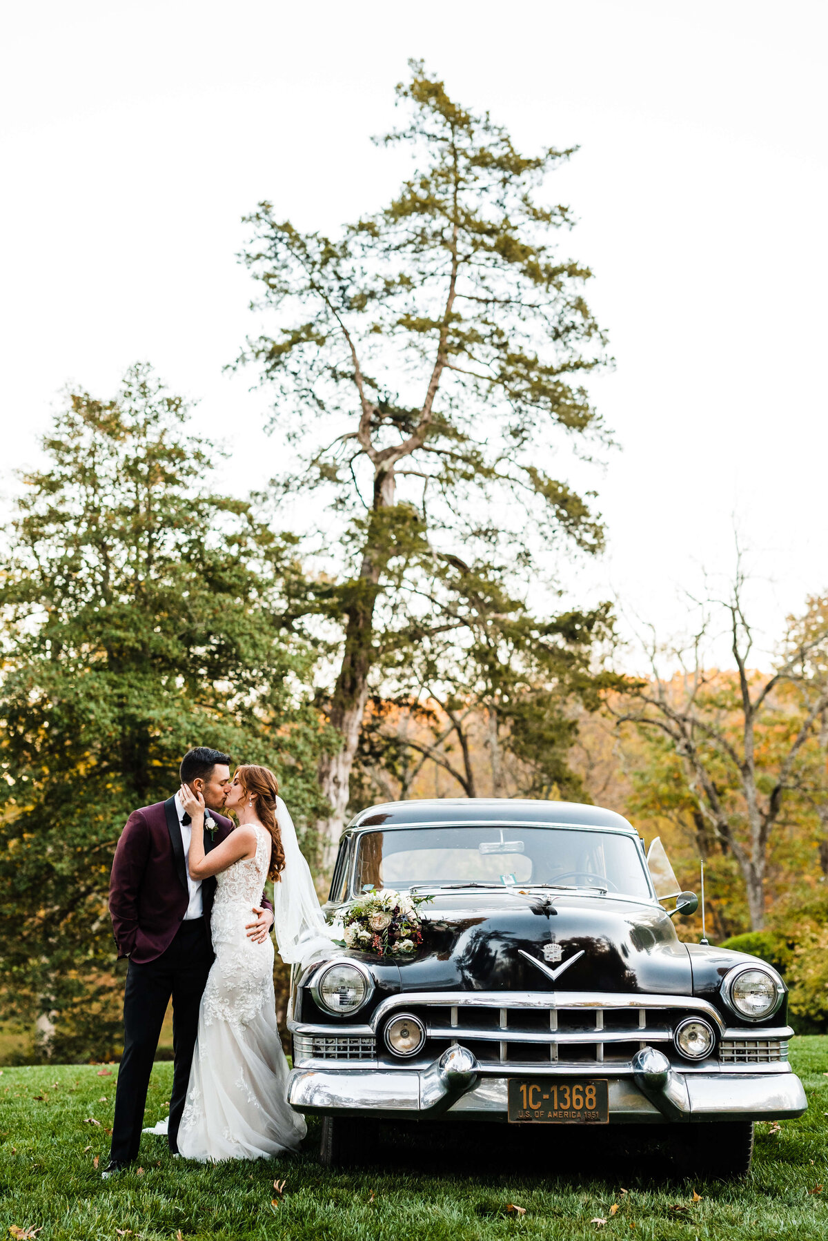 bridal portrait of couples kissing next to a black vintage car in front of a lake photographed by Charlottesville wedding photographer
