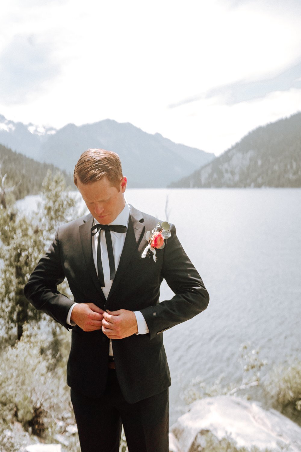 Groom adjusting his suit jacket