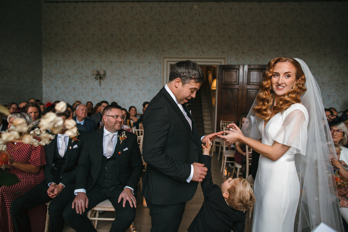 couple making their vows interupted by their small son offering a Haribo ring