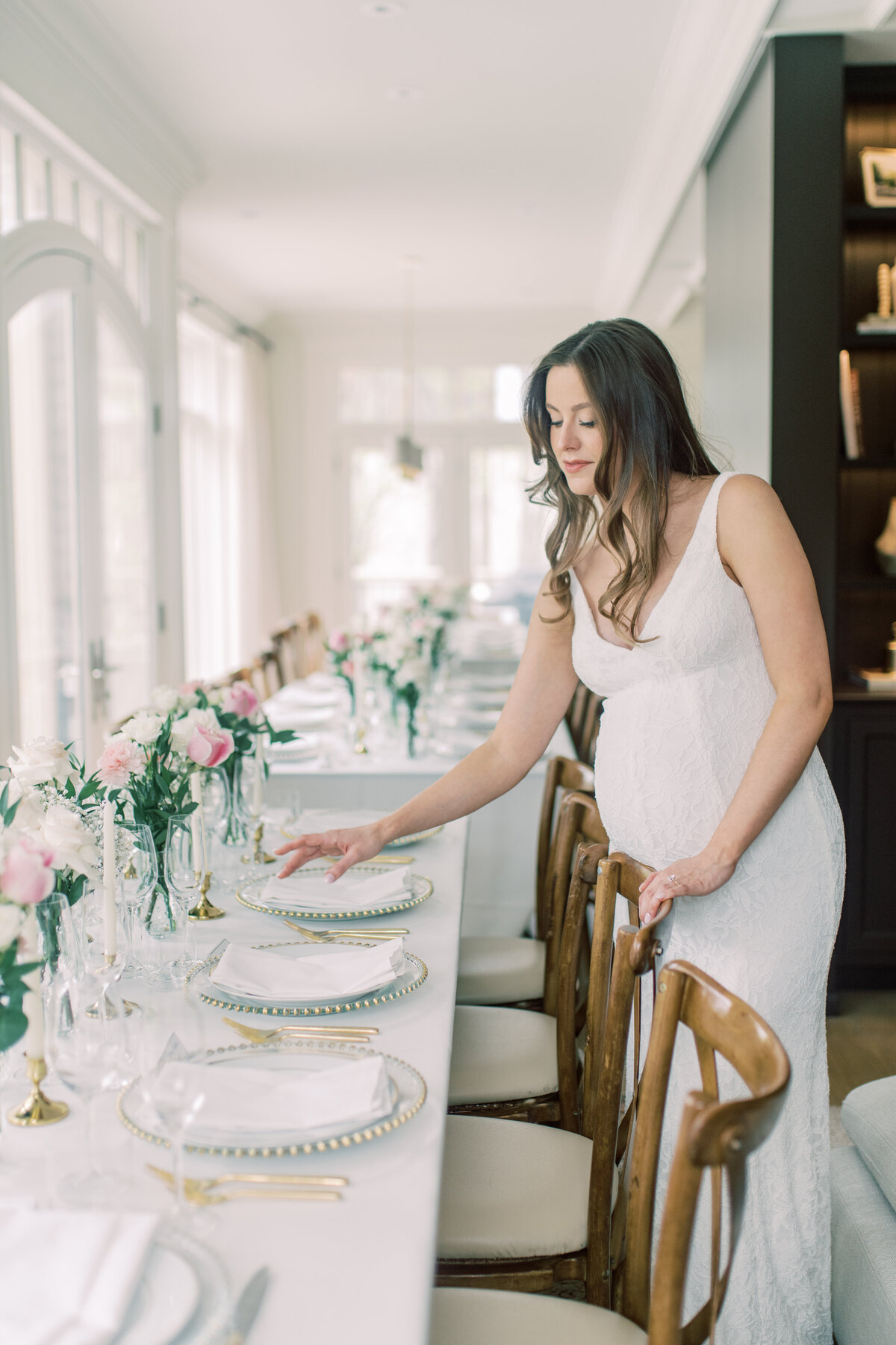 A sophisticated dining room setup with a long table decorated with pink and white flowers, creating a romantic atmosphere for a wedding celebration
