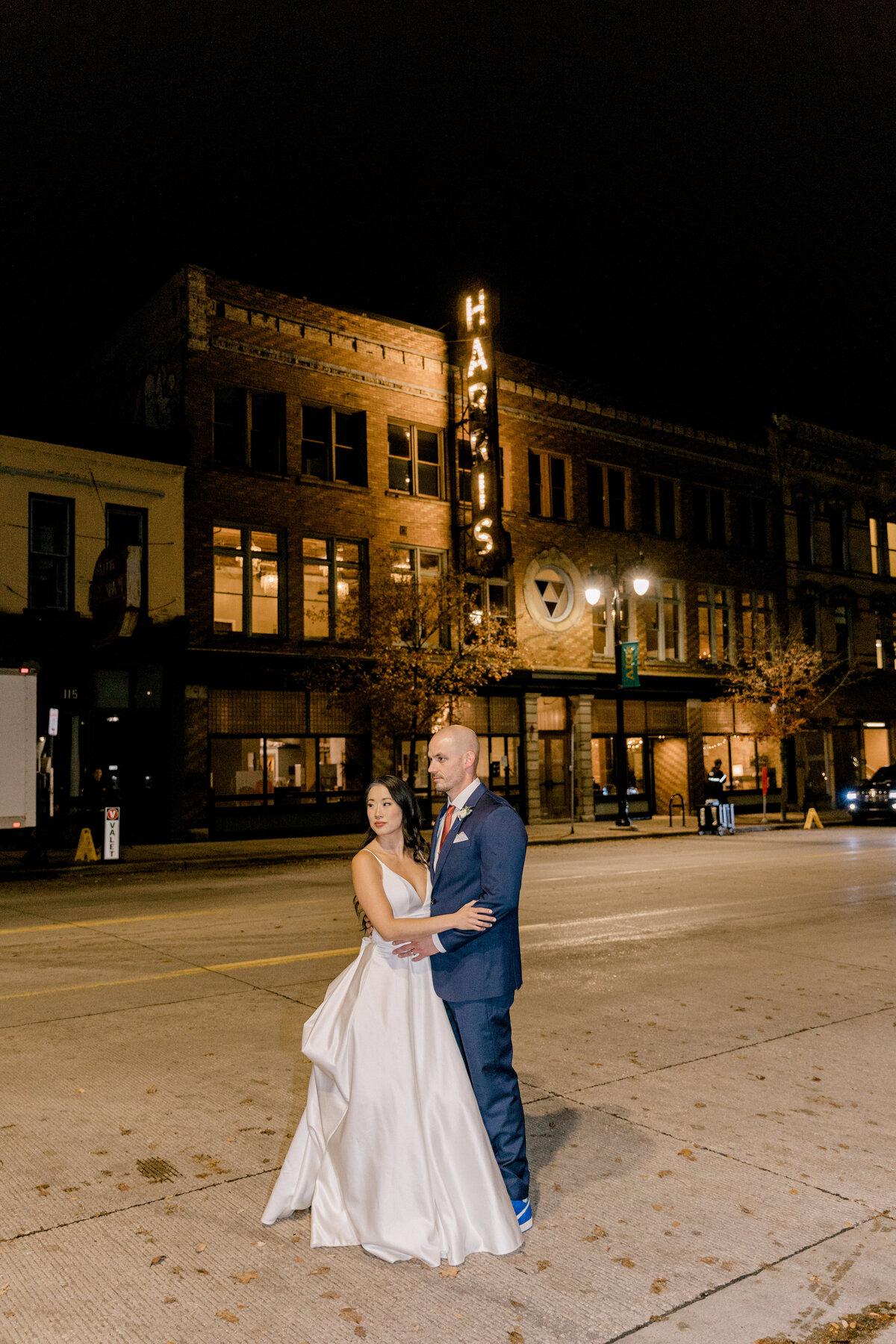bride and groom outside of venue at night