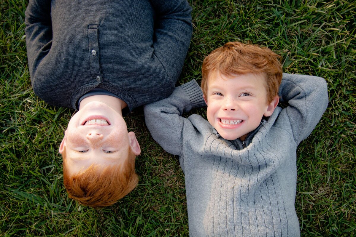 BOYS-RED HAIR-LAYING-GRASS