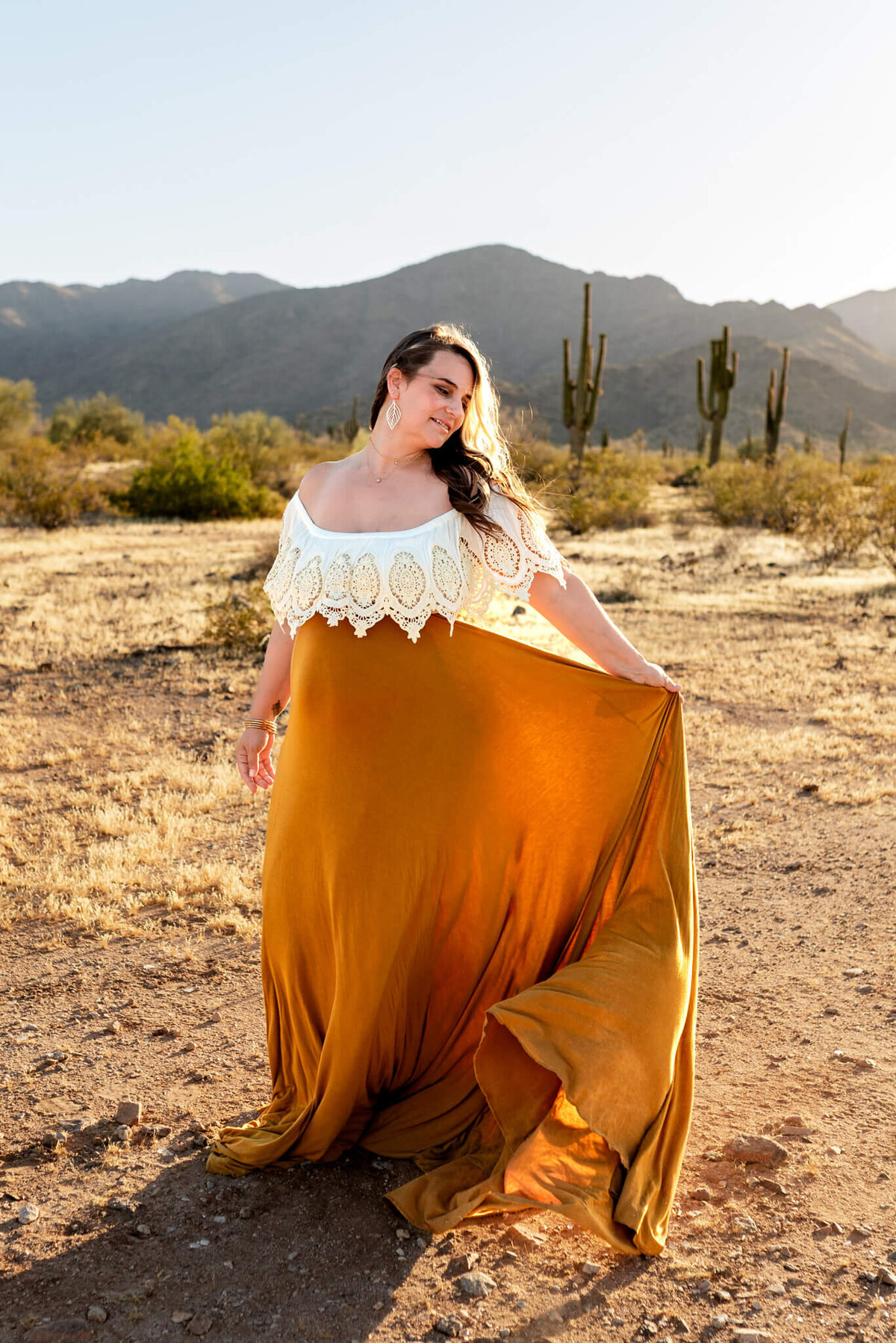 Pregnant mom twirling long dress for maternity portrait captured by Arizona photographer