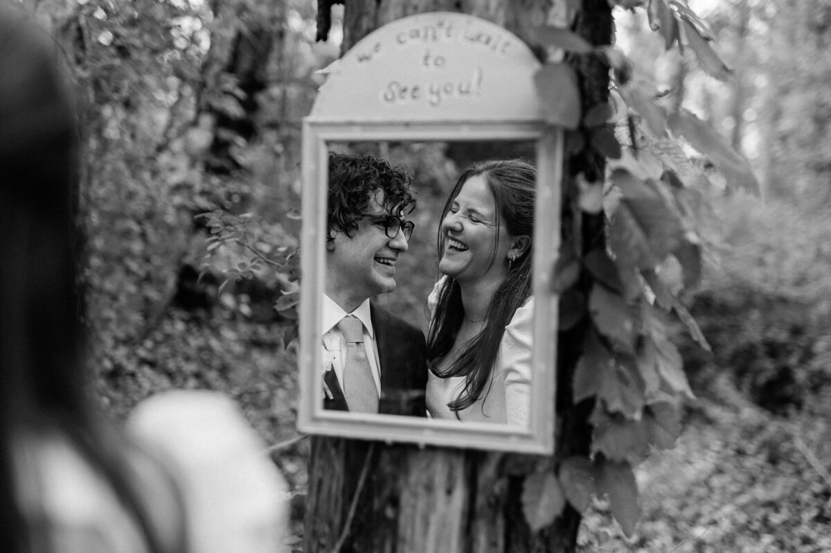 Bride and groom smiling at each other in mirror reflection