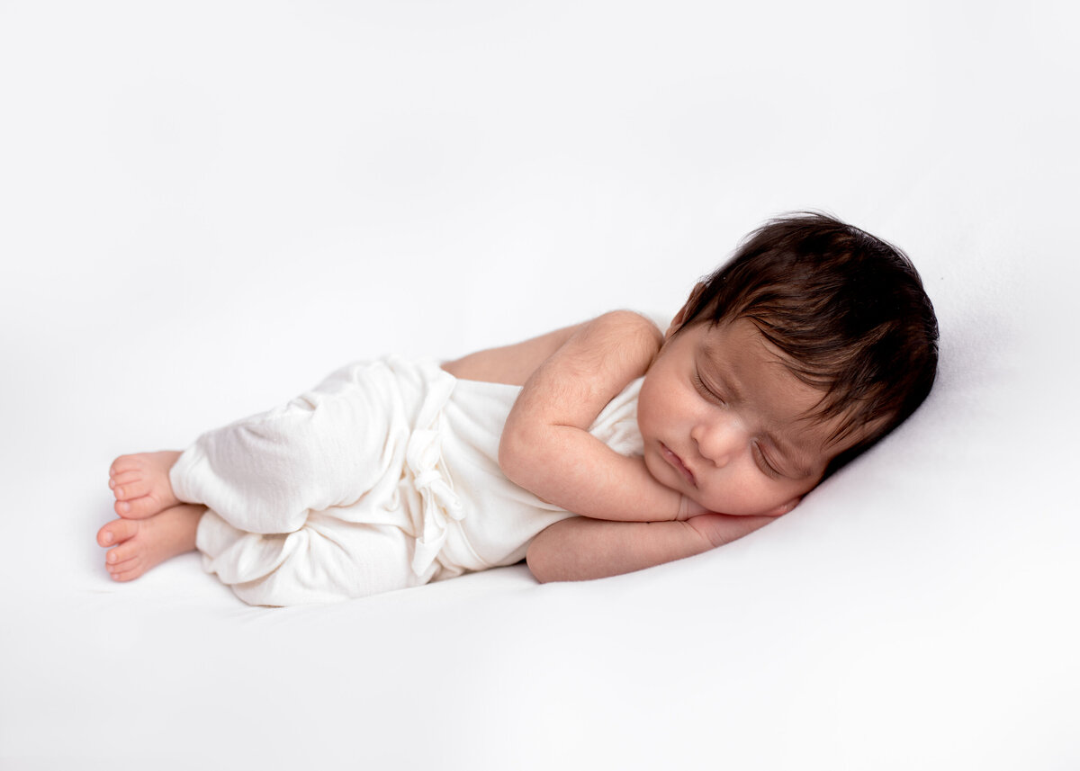 Sleeping newborn boy on a white background during a studio newborn photography session with Lauren Vanier photography