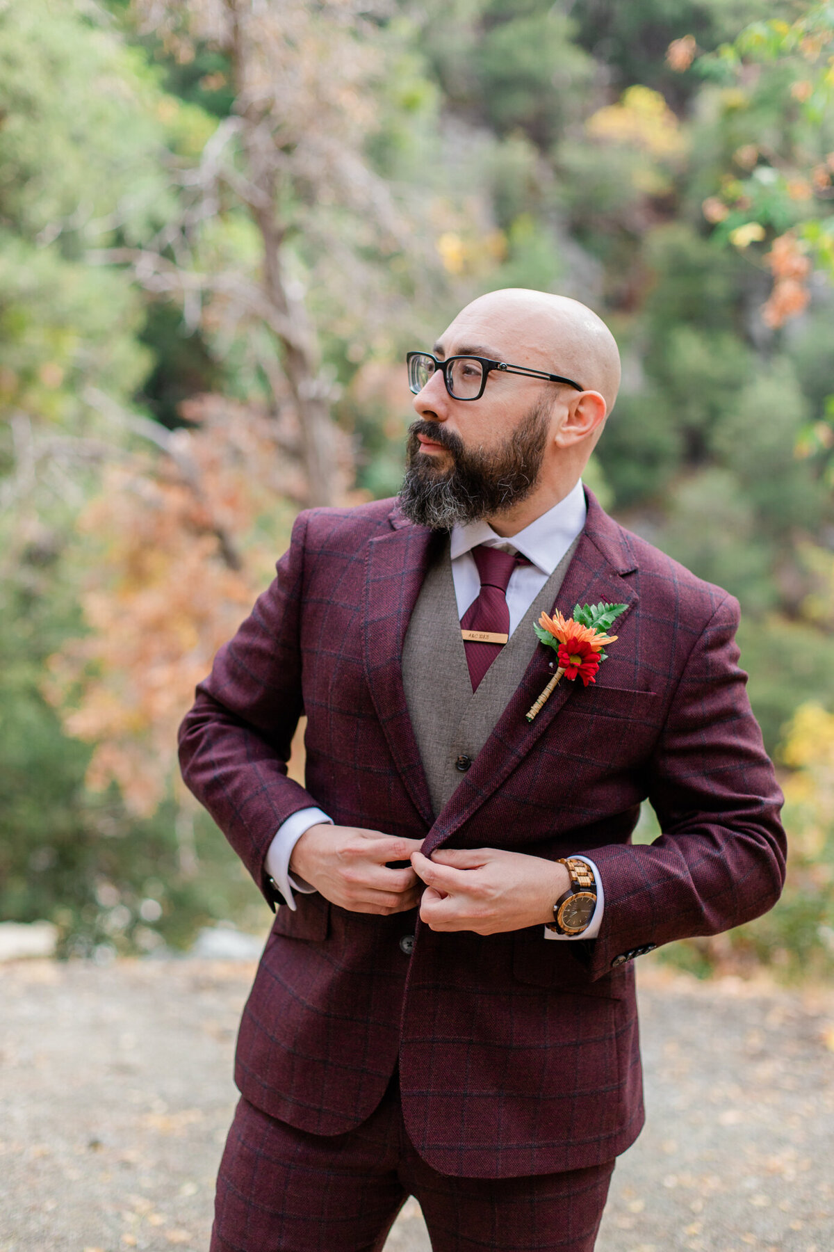 groom buttoning suit jacket