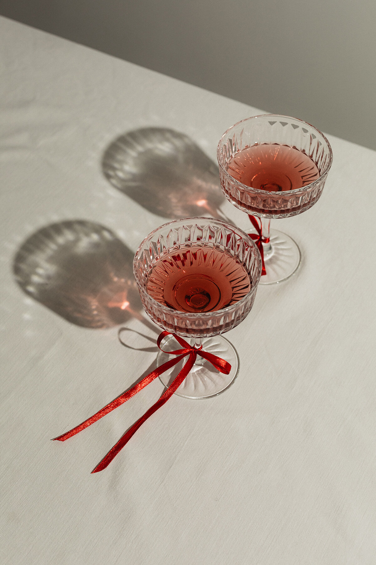 kaboompics_elegant-toast-vintage-wine-glasses-with-red-ribbon-accents-34635