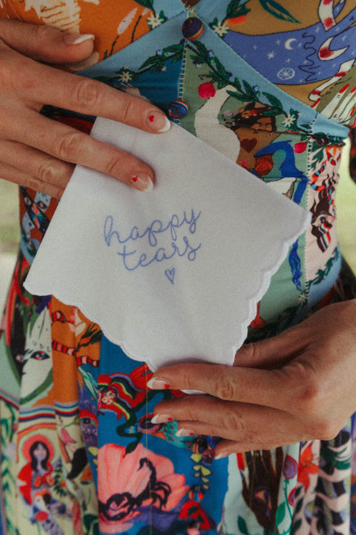 Girl holding a handkerchief that says "happy tears"