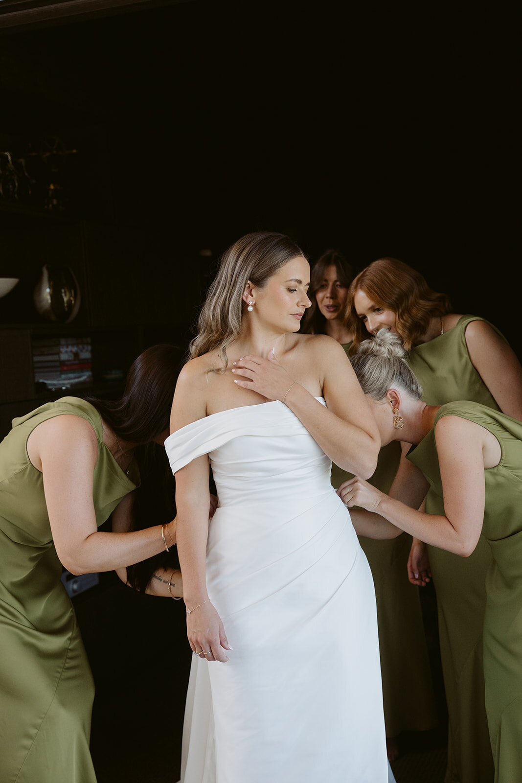 bride and bridal party getting in dress for wedding in new zealand