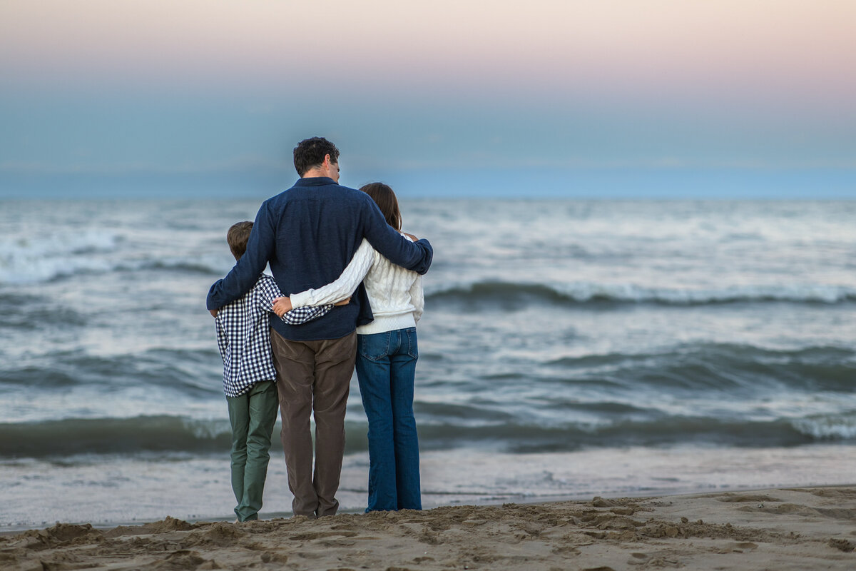 family snuggles on the beach in chicago