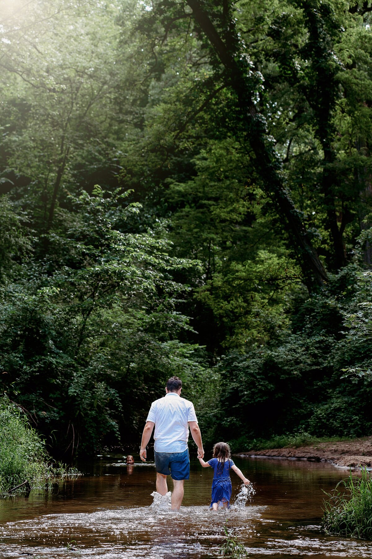Father walking with child in creek McKennaPattersonPhotography