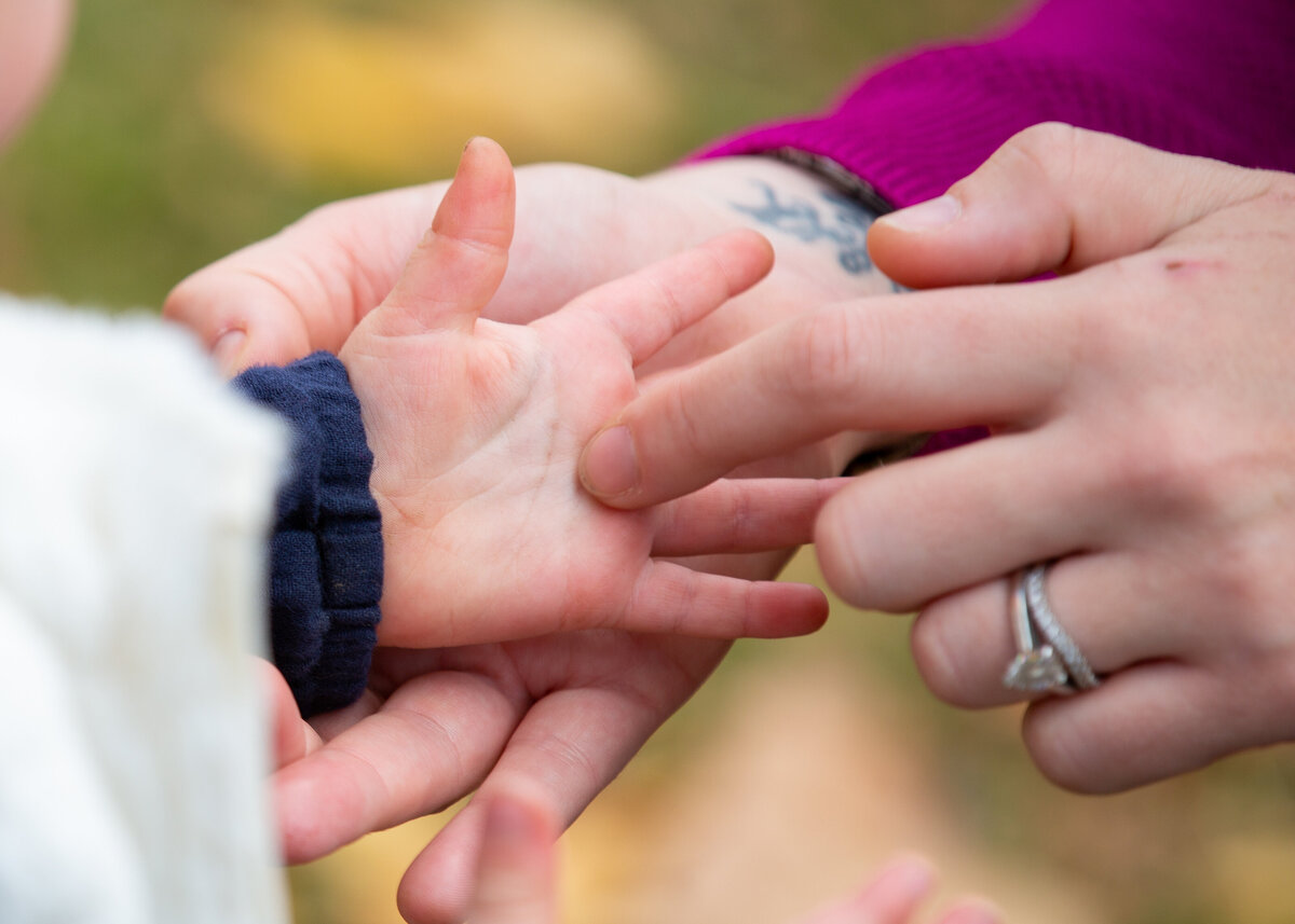 Mother tracing finger over toddler's palm hand