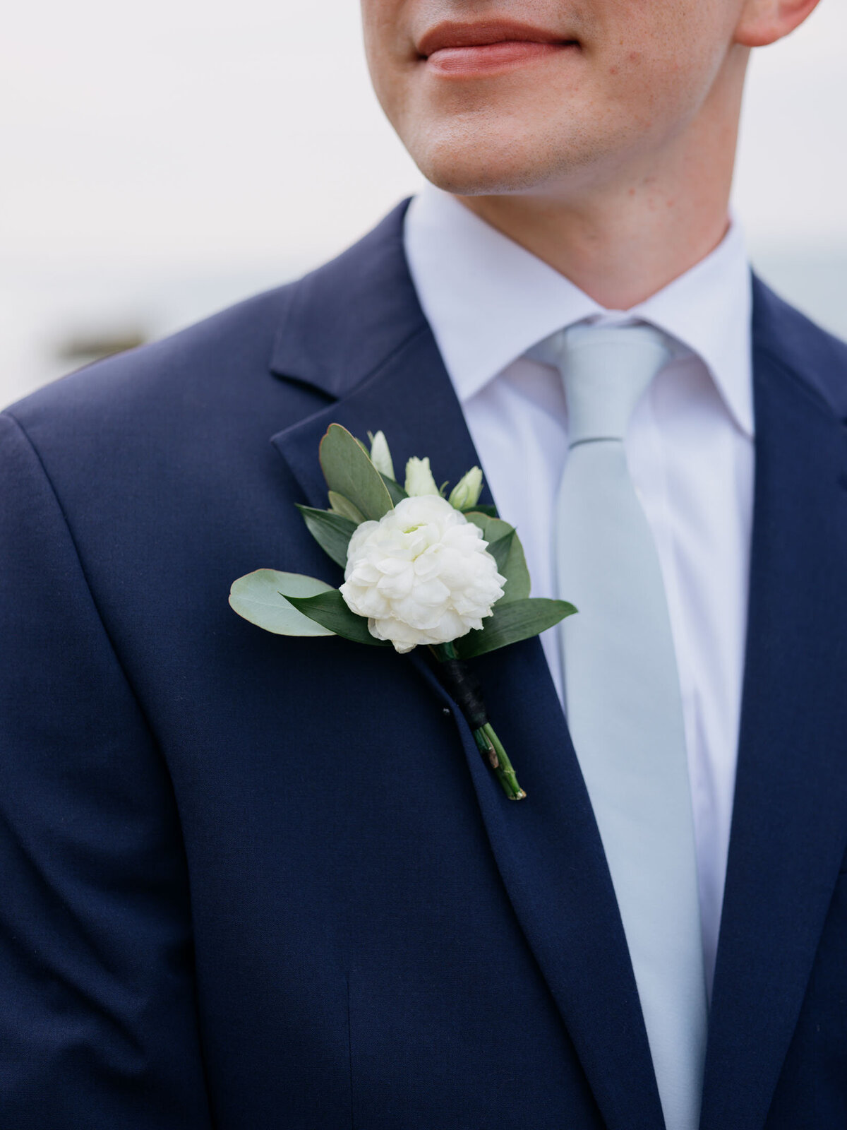 Groom's boutonniere on a navy blue suit