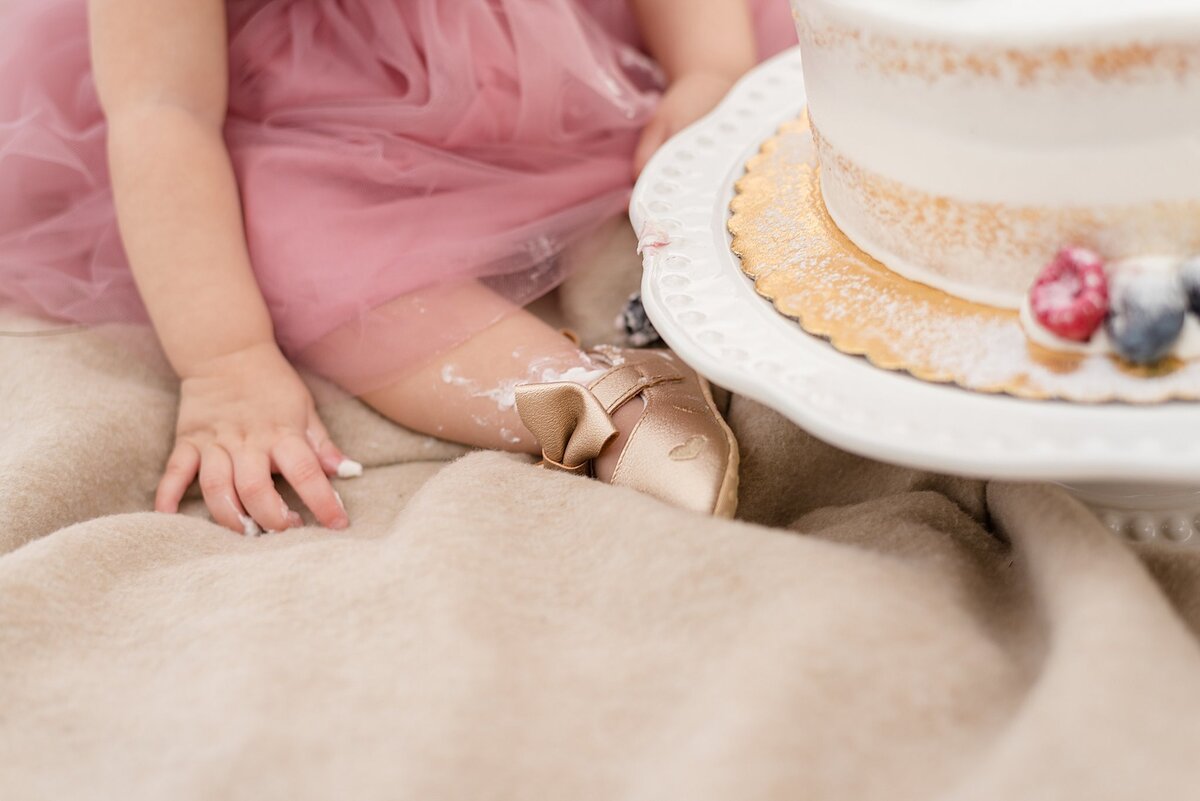 little girls hands next to cake