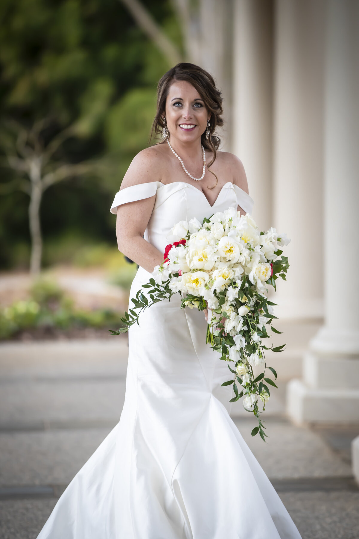Bride smiling while holding bouquet.
