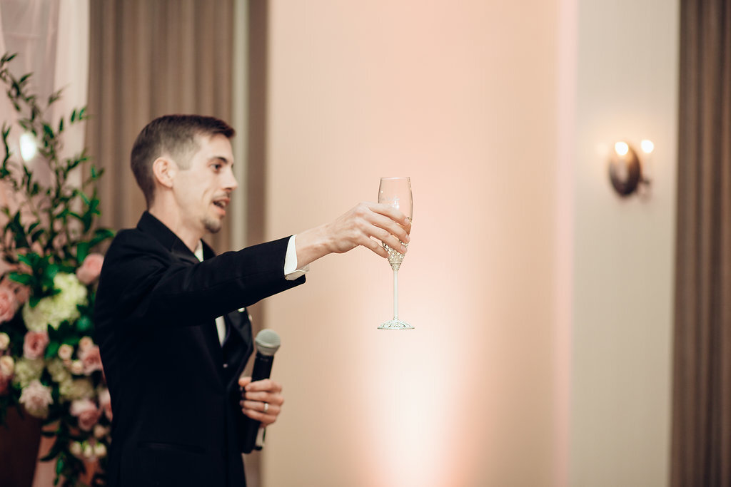 Wedding Photograph Of Groom In Black Suit Raising a Wine Glass Los Angeles