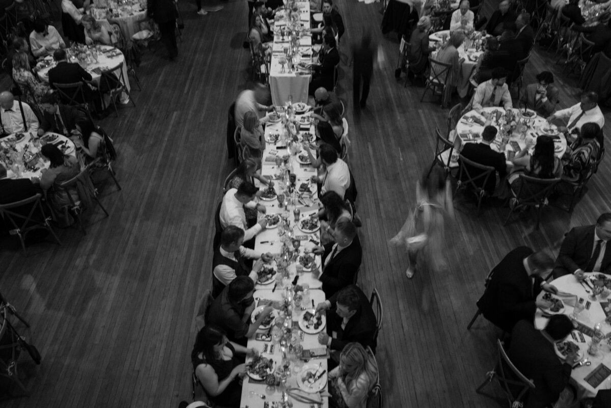 View looking down at people sitting at tables eating at a wedding reception 