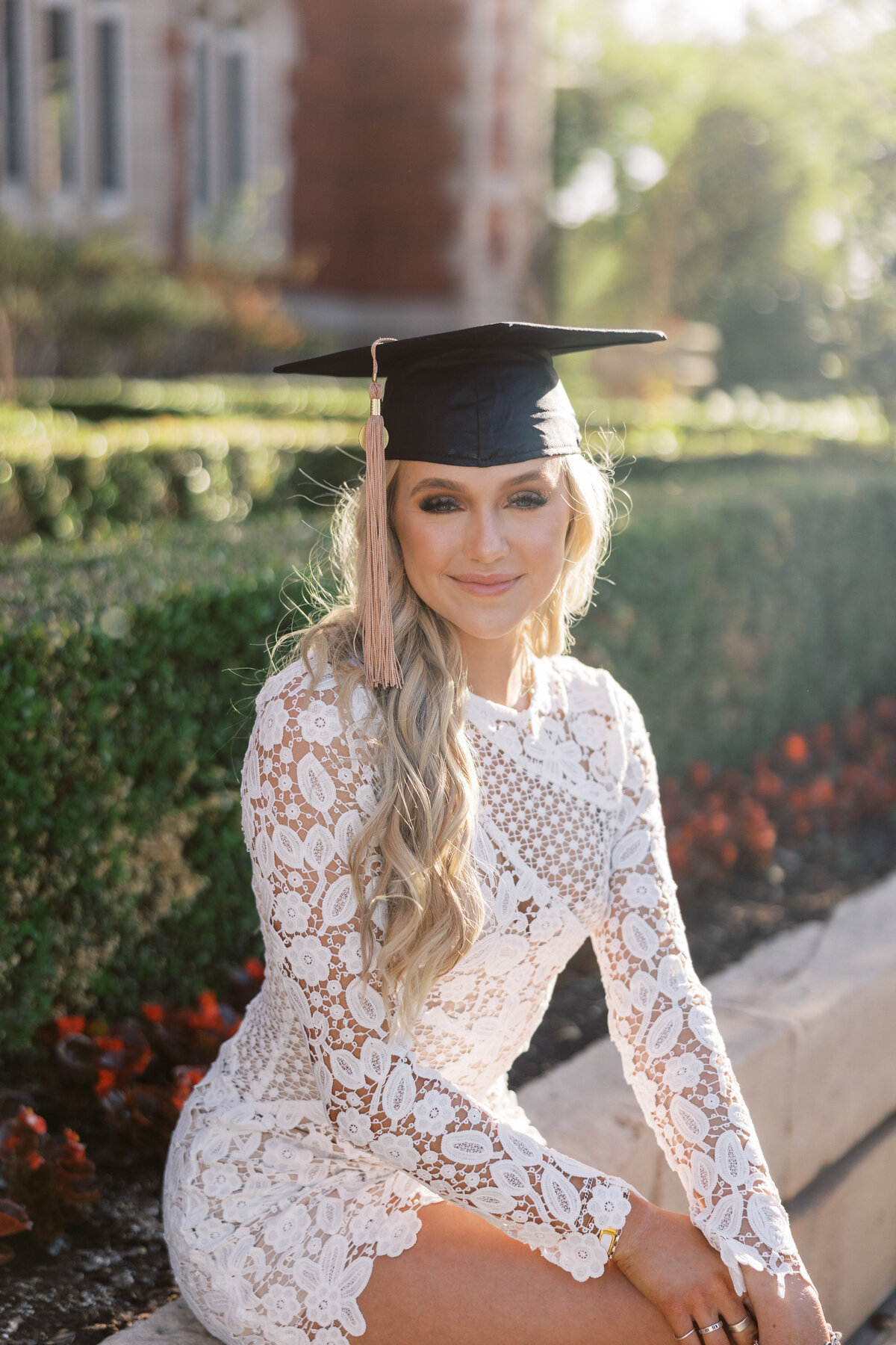 OU track and field star poses in cap in front of administrative building for senior session