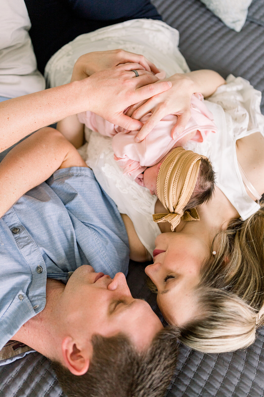 Parents snuggling newborn baby