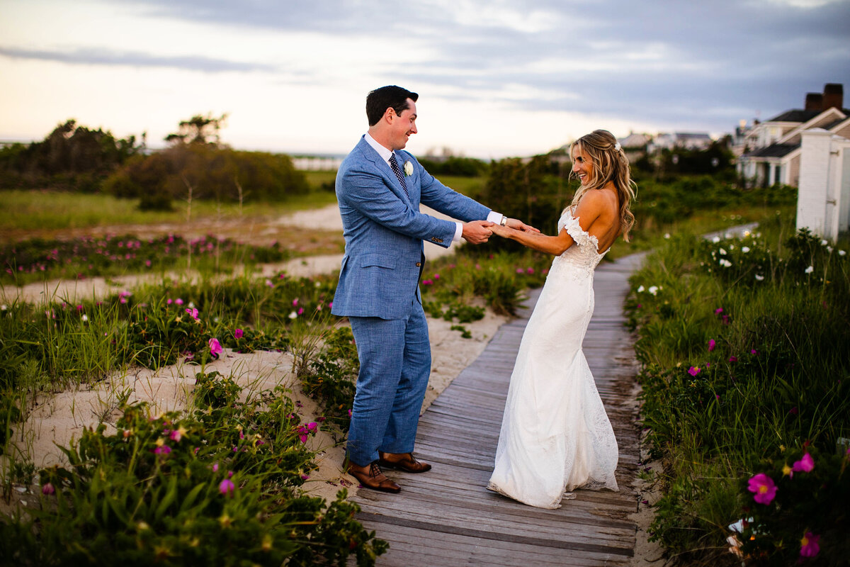 A wedding couple on the beach walkways at Chatham Bars Inn at sunset.