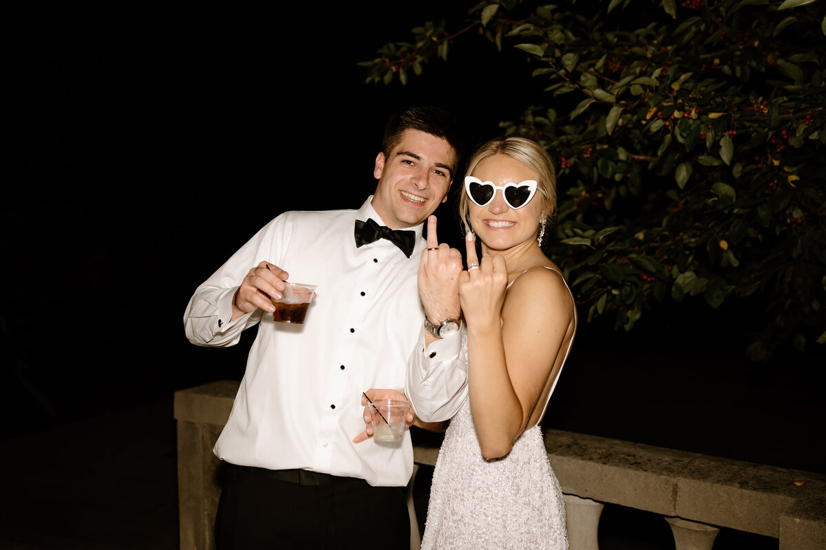 bride and groom showing off their rings 