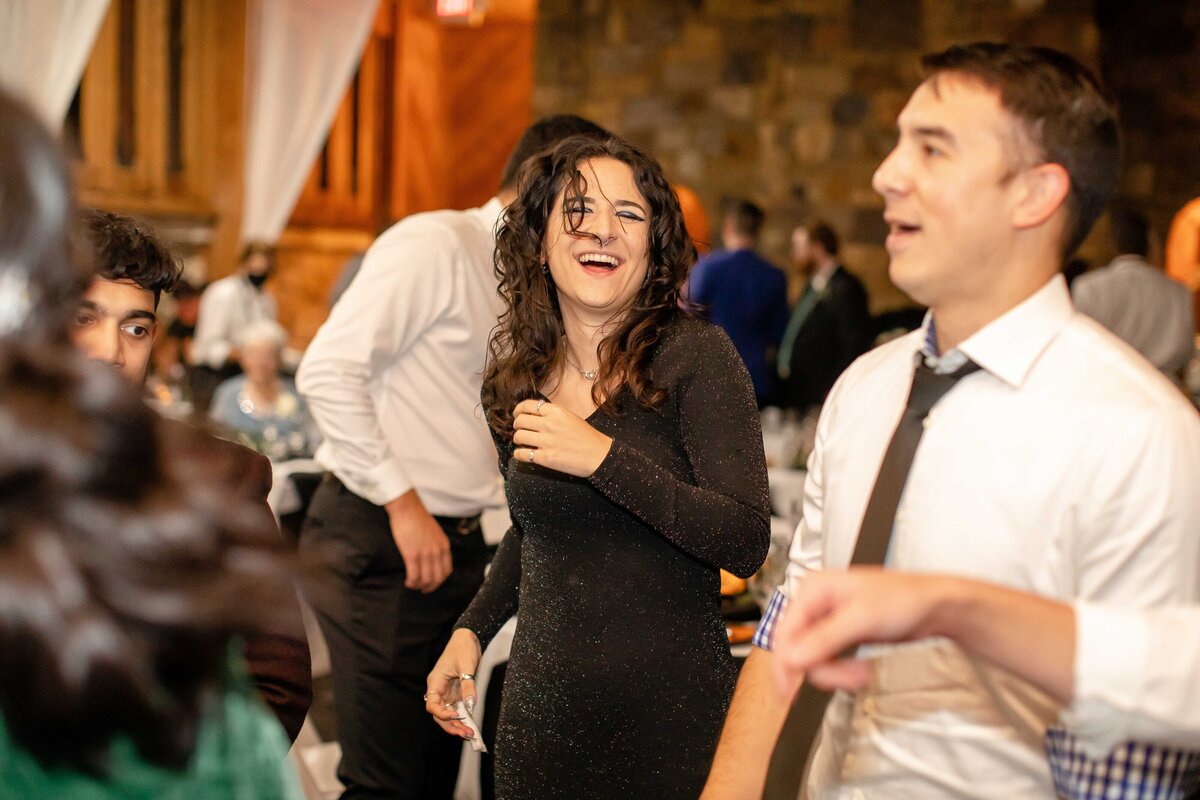 woman in curly hair laughs while dancing at Milltown HIstoric District wedding