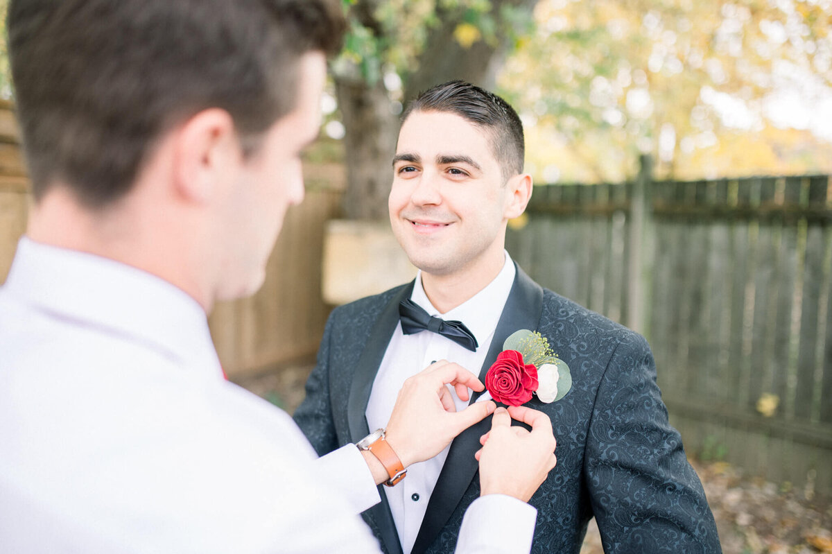 Niagara wedding photographer captures the best man equipping the boutineer to the groom