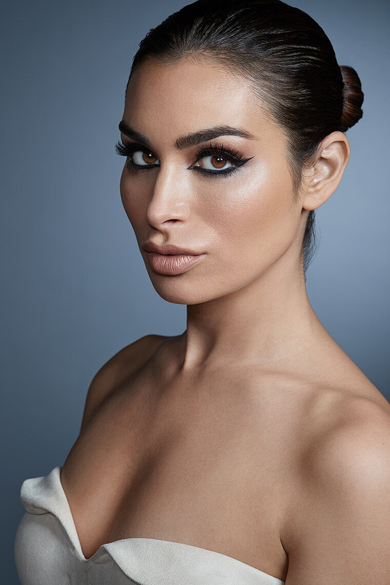 Refined portrait of Ashley with subtle makeup and a neutral expression, captured in a studio by Ylva Erevall.