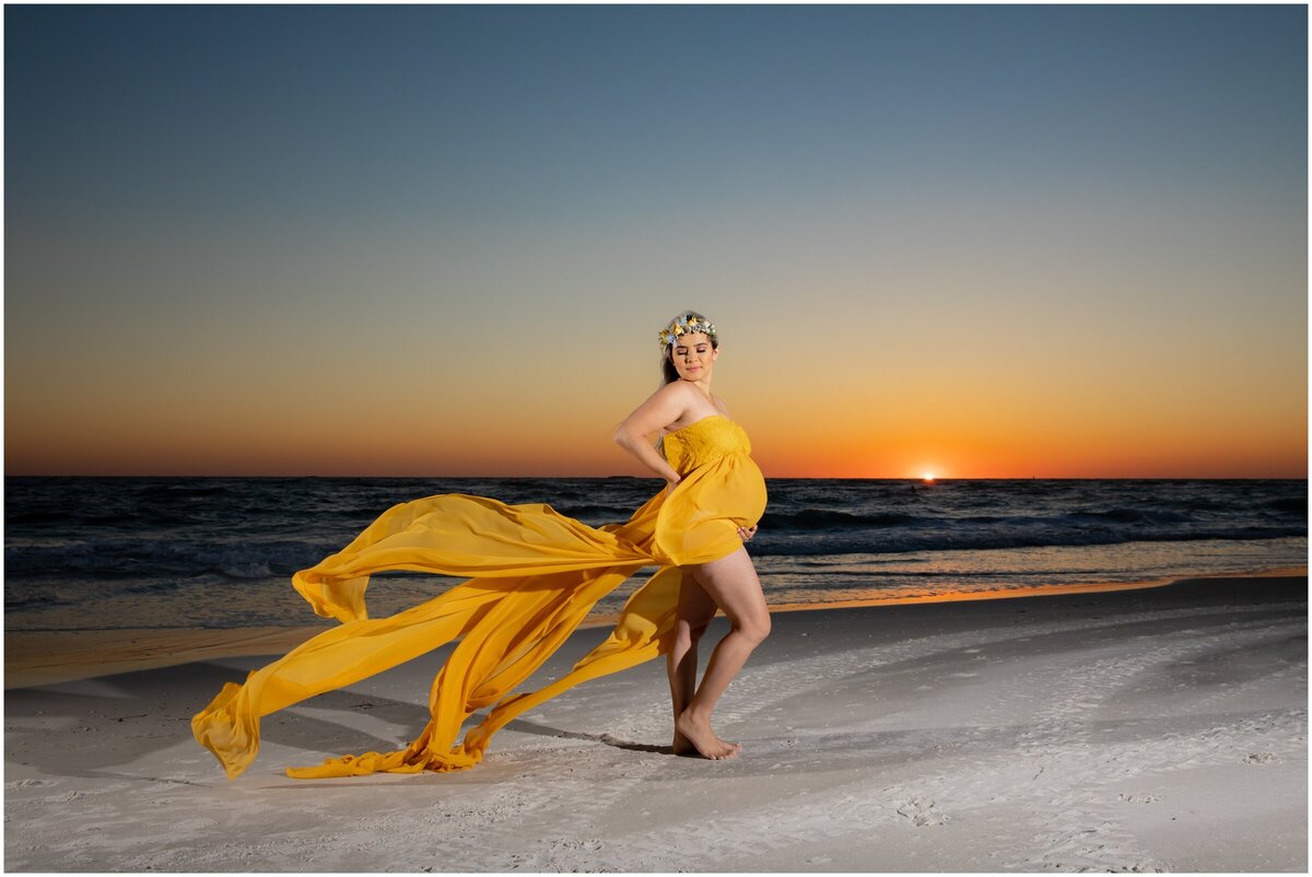 maternity portrait in yellow flowy dress at sunset on Anna Maria Island