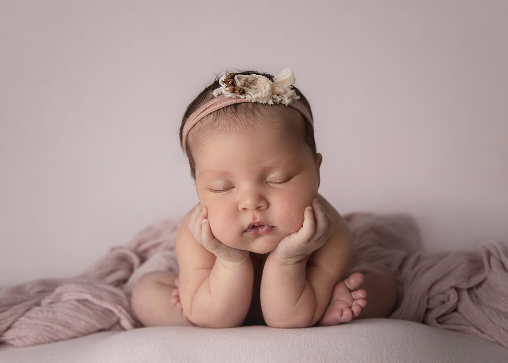 NEWBORN_BABYGIRLINFROGGYPOSEWITHFLOWERHEADBANDPINK