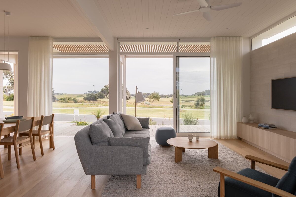 Living room with timber ceiling and large windows in a home built by LRC Custom Builders.