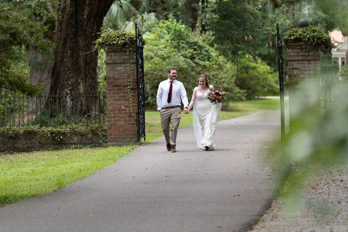 A newlywed couple holding hands and laughing together 