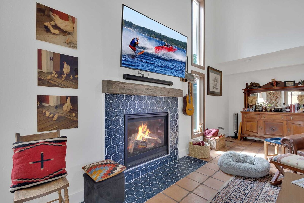 A fireplace with blue honeycomb styled tile and a wooden mantel.