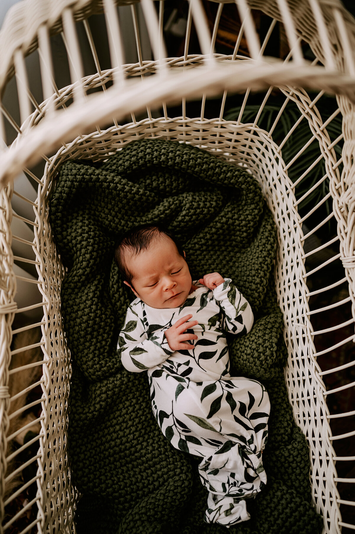 newborn snuggled in bassinet