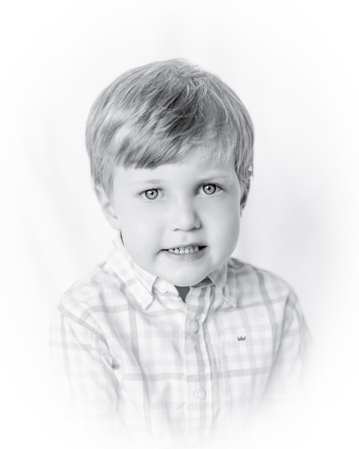 Black and white vignetted portrait of a little boy