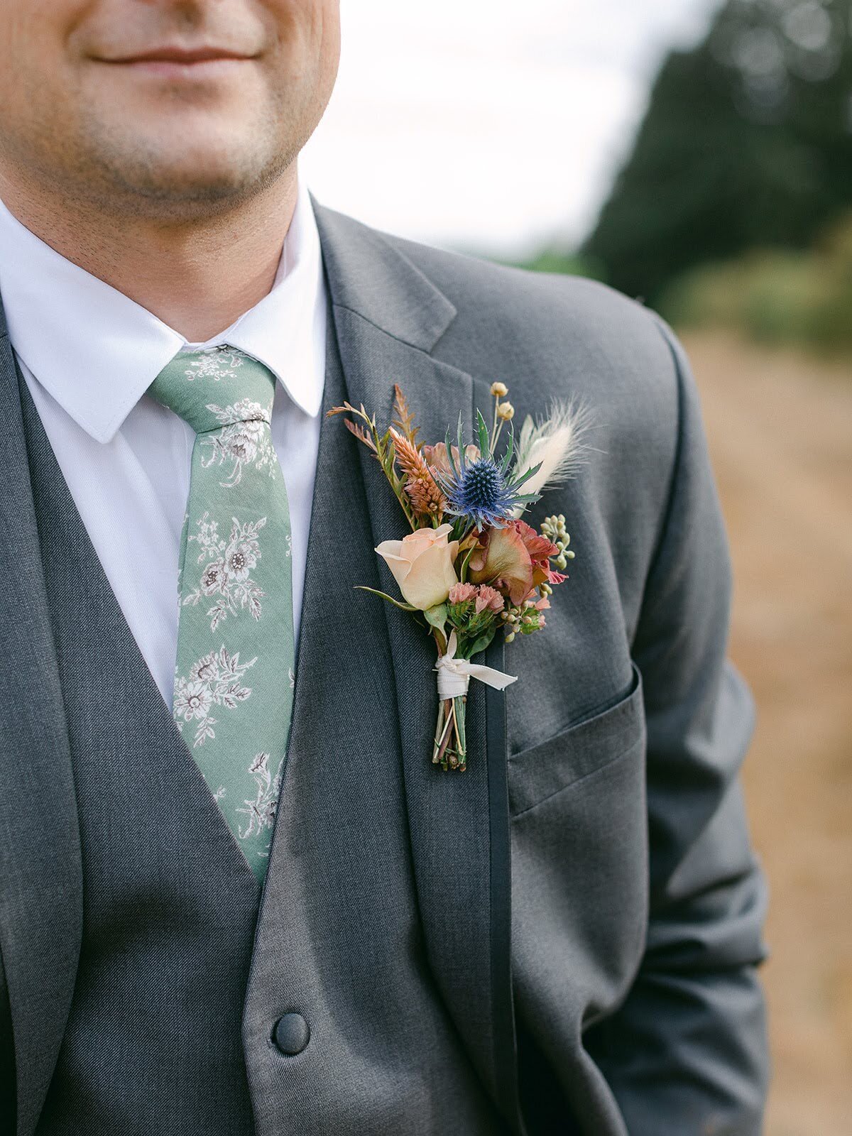 A floral boutonniere pinned onto a suit for wedding party member.