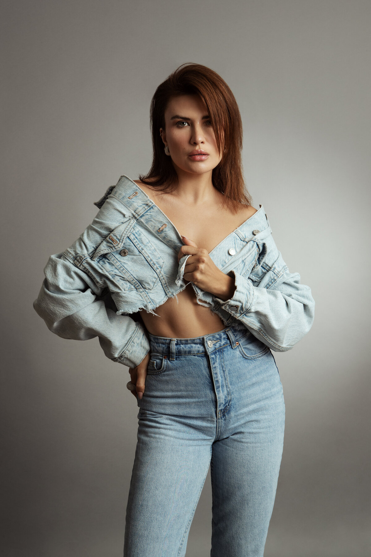 Playful portrait of Alina Gorun in a chic outfit, exuding confidence against a simple backdrop, captured by Ylva Erevall.