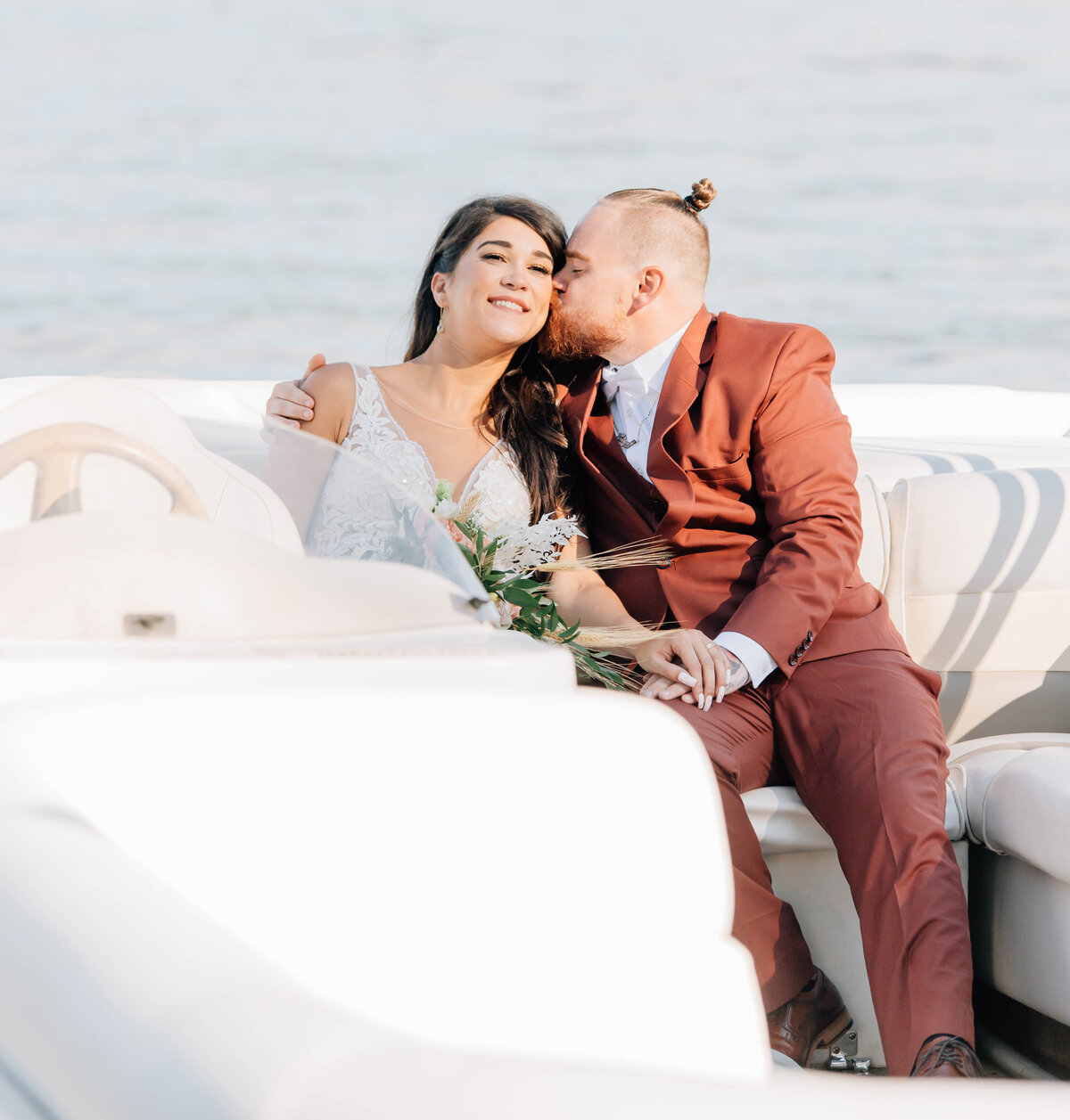 A bride and groom share an intimate moment on a boat during their Vermont elopement. Warm, heartfelt, and artfully captured wedding photography.