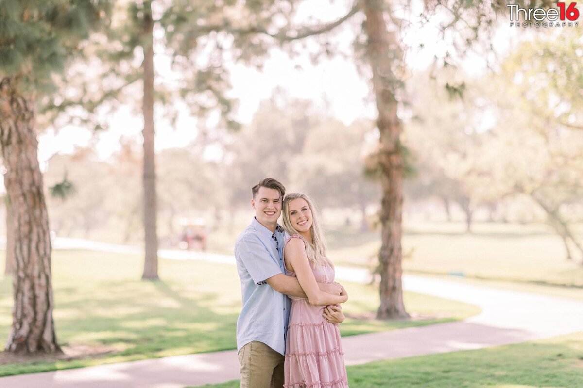 Bride to be leans back into her Groom at a Mile Square Park engagement session