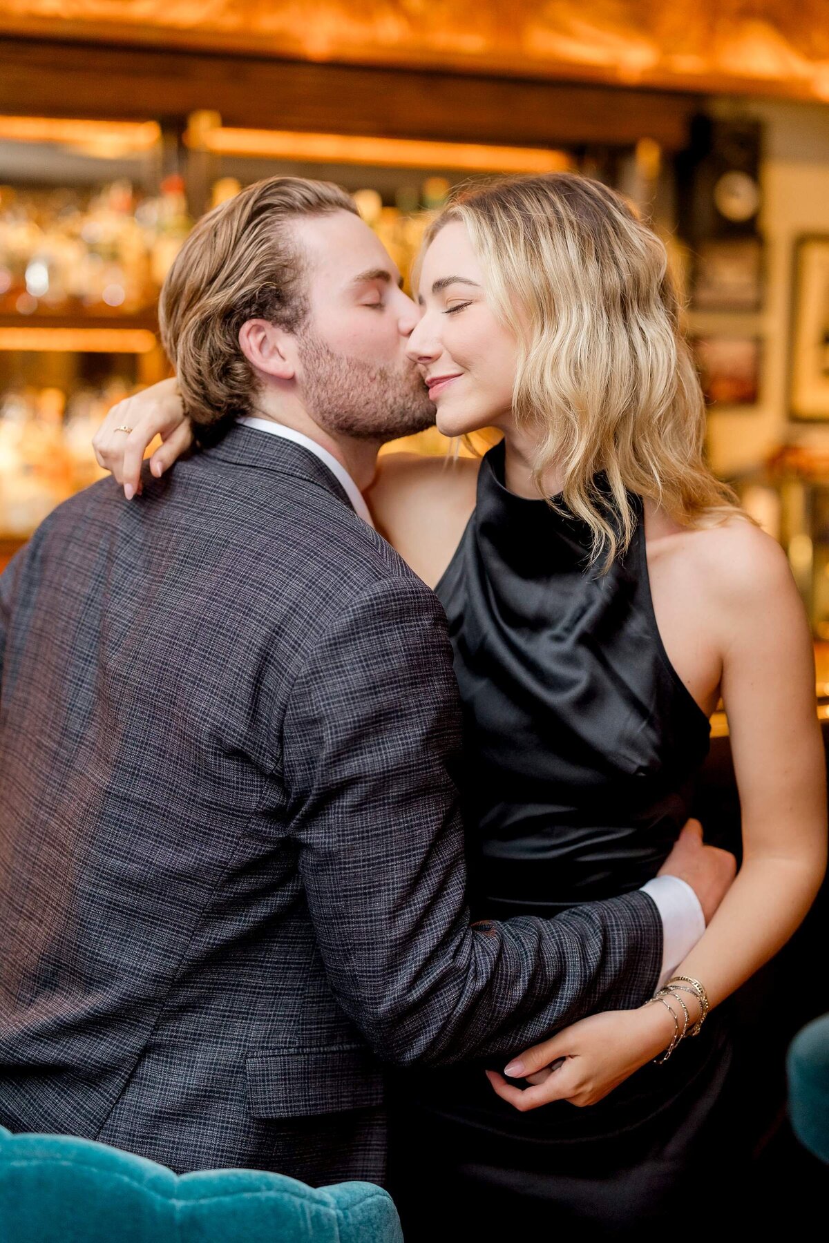 Rainy engagement session in downtown Minneapolis captures the love between a modern couple as they cozy up at the bar with a drink in hand
